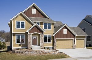 Brownandbalanced-300x195 The image displays a modern single-family home featuring a mix of siding materials, notably wood siding on parts of the exterior.