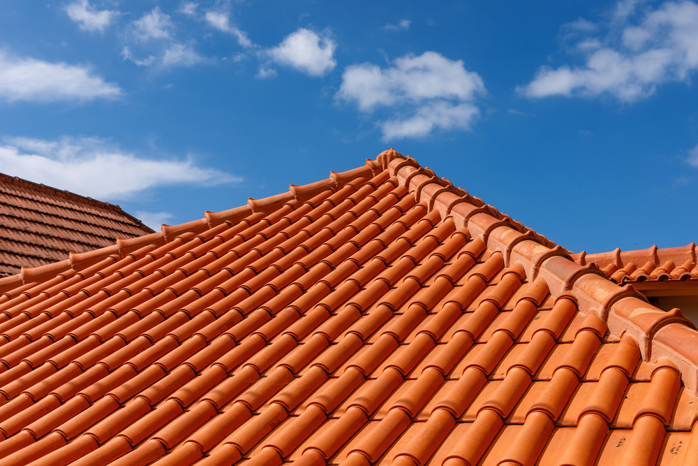 Red tiles panels roof under blue sky
