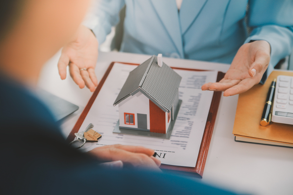 Real estate agent talked about the terms of the home purchase agreement and asked the customer to sign the documents to make the contract legally, Home sales and home insurance concept.