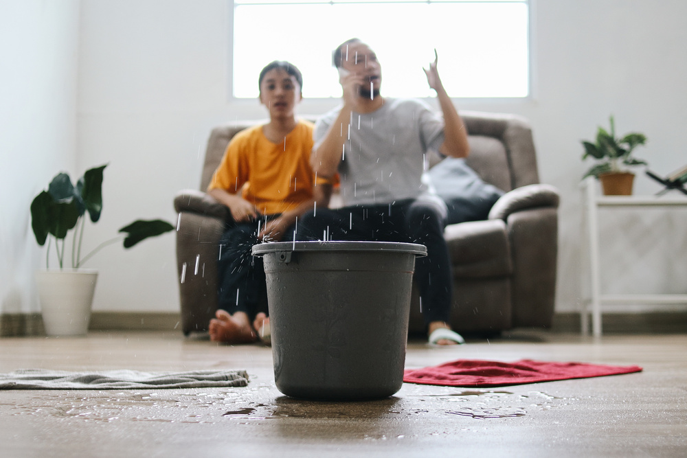 Water drips into buckets in living room as frustrated family calling for insurance company